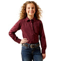 Young girl wearing a maroon shirt and blue jeans on a white background