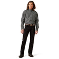 Man wearing a patterned shirt and black pants on a white background