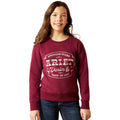 Girl wearing a maroon sweatshirt with 'Ariat' branding on a white background