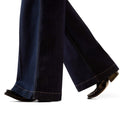 Dark blue jeans being worn on a white background