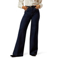 Person wearing dark blue wide-leg jeans on a white background