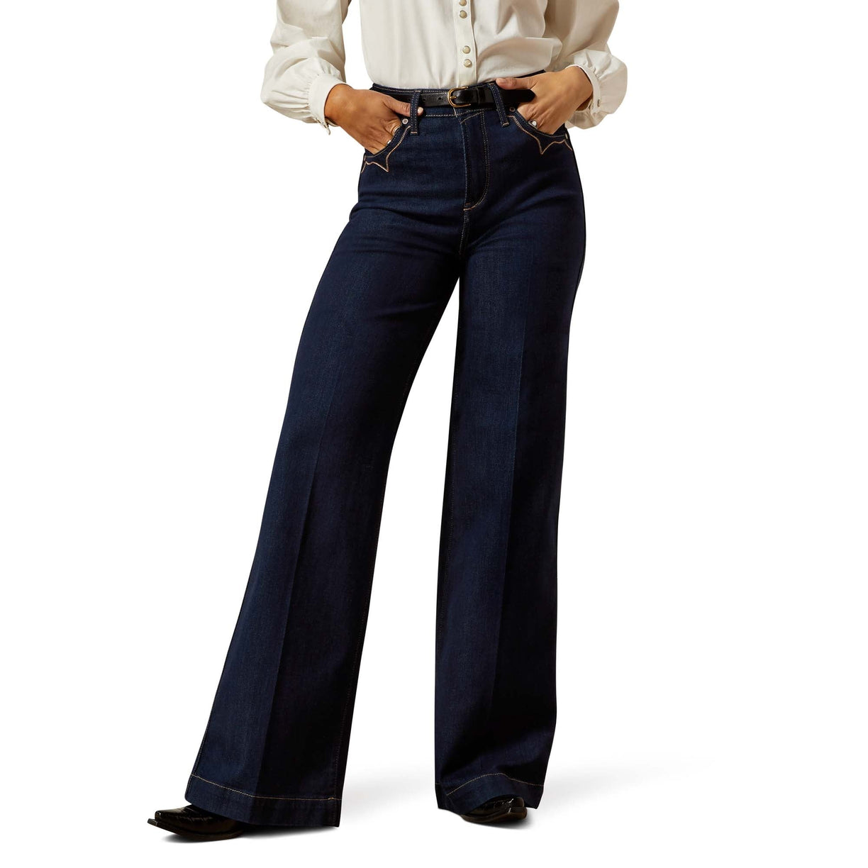 Person wearing dark blue wide-leg jeans on a white background