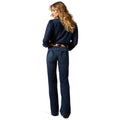 Woman wearing a navy blue sweater and jeans on a white background