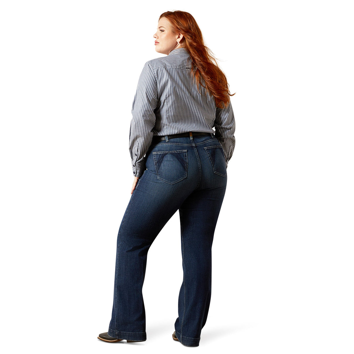 Woman wearing blue jeans and a striped shirt on a white background