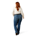 Woman behind wearing dark blue denim jeans, features boot leg, mid rise, flare, cowgirl, casual, everyday jeans pocket detail and belt loops.
