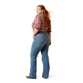 Woman wearing blue jeans and a plaid shirt on a white background