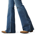 Blue jeans worn with brown shoes on a white background