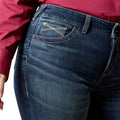 Close-up of blue jeans worn by a person with a red shirt.