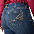Close-up of blue jeans with a person wearing them, focusing on the back pocket.