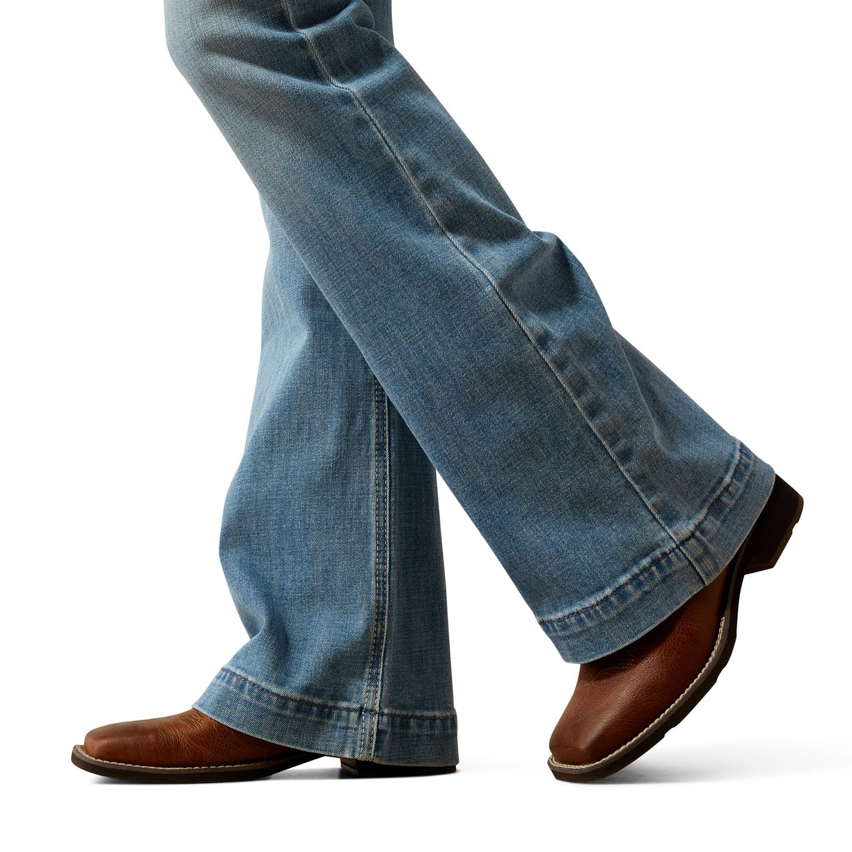 Close-up of blue jeans and brown shoes on a white background
