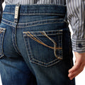 Close-up of blue jeans with a visible brand label on a white background