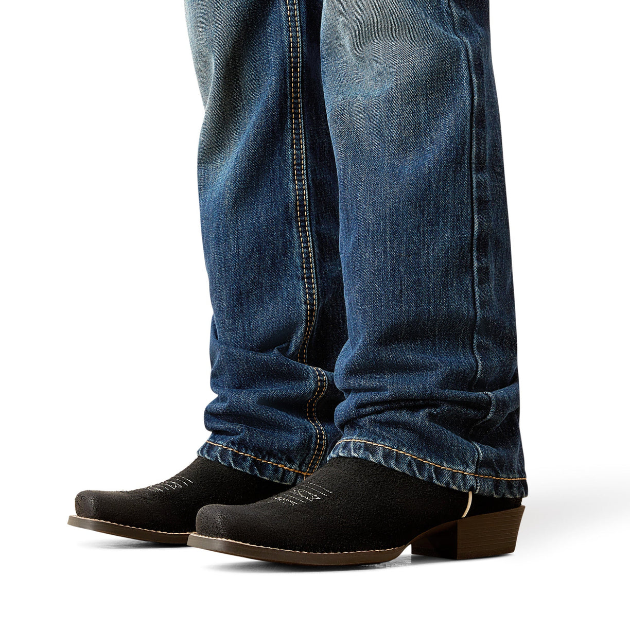 Close-up of blue jeans and black boots on a white background