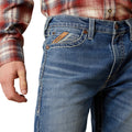 Close-up of blue jeans with a plaid shirt on a white background