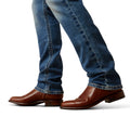 Brown leather boots and blue jeans on a white background