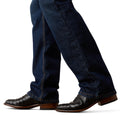 Dark blue jeans worn with brown leather boots on a white background