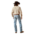 Person wearing a beige shirt, light blue jeans, and a brown hat on a white background