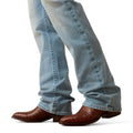 Blue jeans with brown cowboy boots on a white background