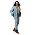 Woman wearing a denim jacket and jeans on a white background