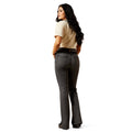 Woman wearing dark jeans and a beige shirt on a white background