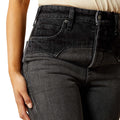 Close-up of black jeans being worn, focusing on the waistband and legs.
