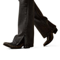 Person wearing black jeans and brown boots on a white background