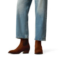Brown ankle boots worn with blue jeans on a white background