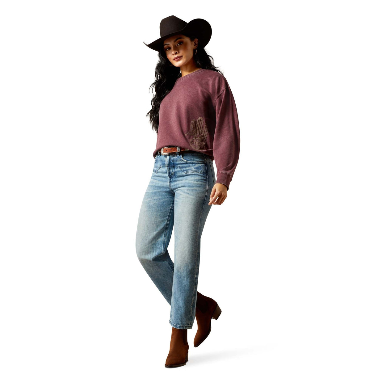 Woman wearing a pink sweater, blue jeans, and a cowboy hat on a white background