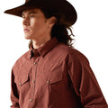 Man wearing a brown cowboy hat and red plaid shirt on a white background