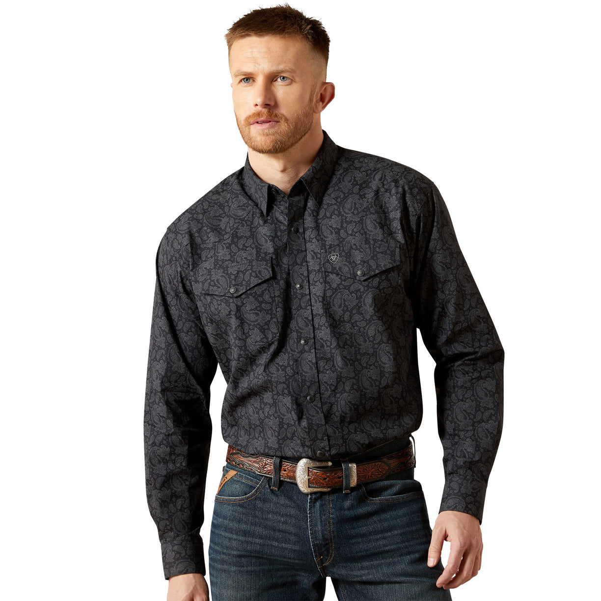 Man wearing a dark patterned shirt and jeans on a white background