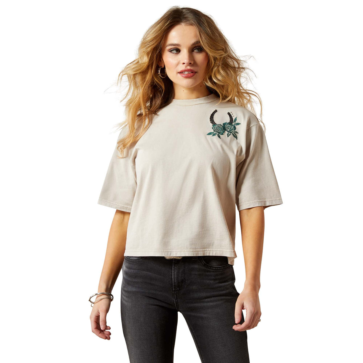 Woman wearing a beige t-shirt with a graphic design on a white background