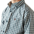 Close-up of a person wearing a green and white plaid shirt with a brand logo on a white background