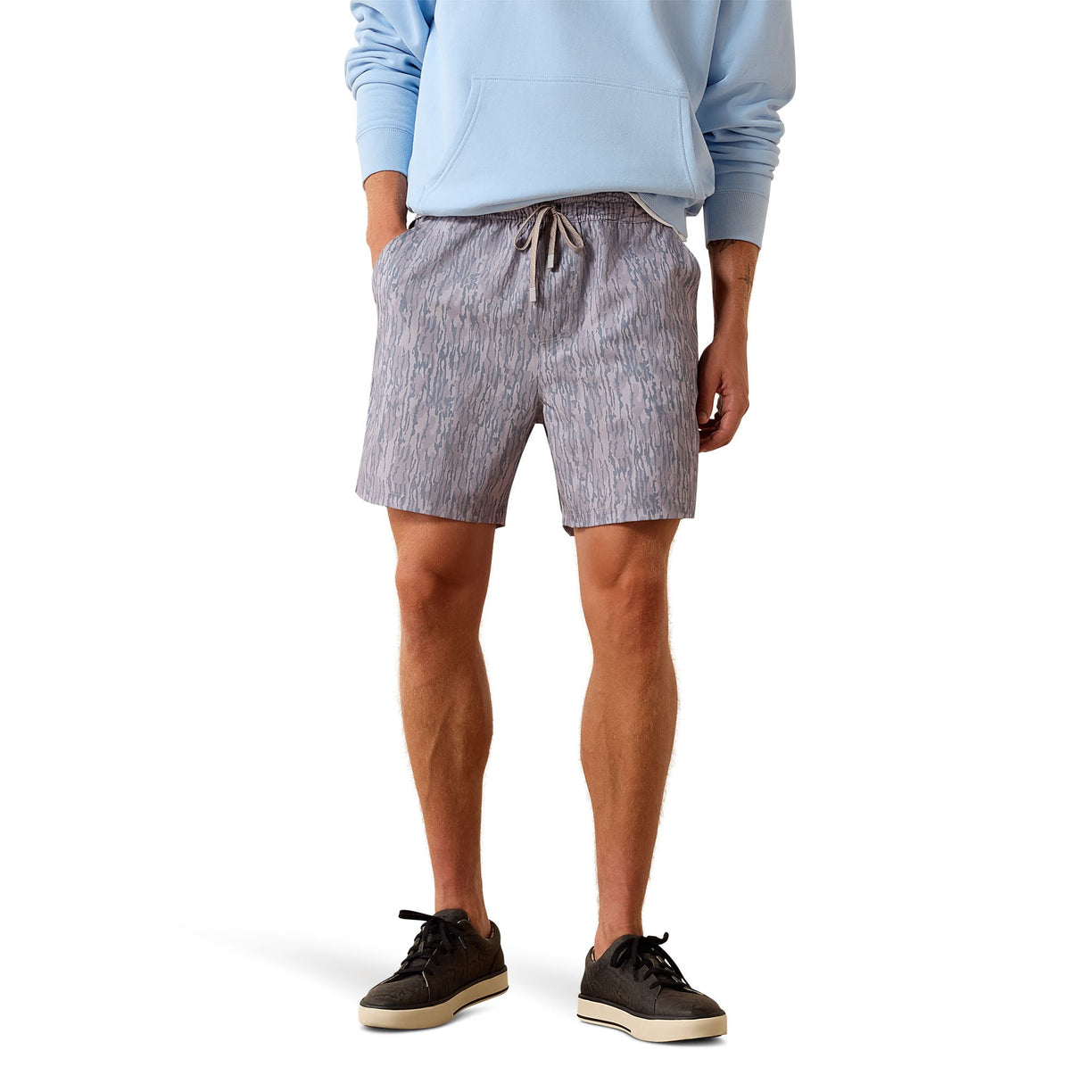 Person wearing gray shorts and a light blue sweatshirt on a white background