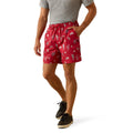 A man wearing red drawstring shorts with a white printed pattern, paired with a gray t-shirt and black sneakers, shown from the waist down on a white background.