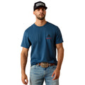 Man wearing a blue t-shirt with a logo, jeans, and a cap on a white background