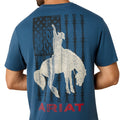 Blue t-shirt with white graphic of a woman on horseback and barbed wire, featuring the Ariat logo.
