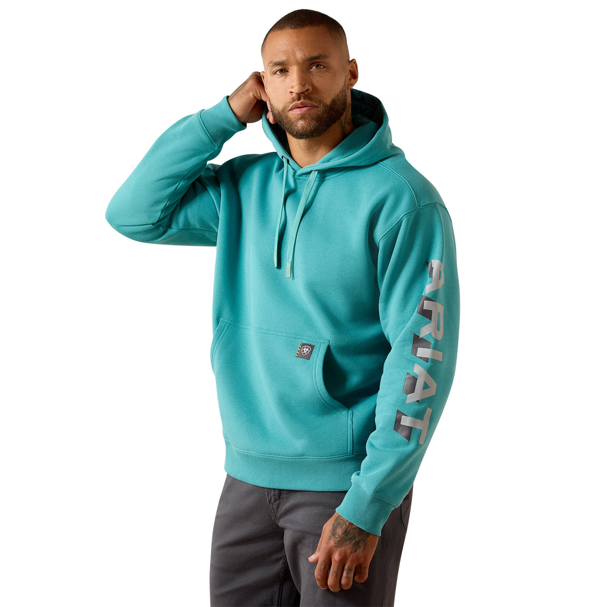 Man wearing a teal hoodie with 'Ariat' branding on a white background