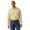 A man wearing a light beige western-style long-sleeve button-down shirt with two chest pockets, paired with blue jeans and a brown belt, against a plain white background.