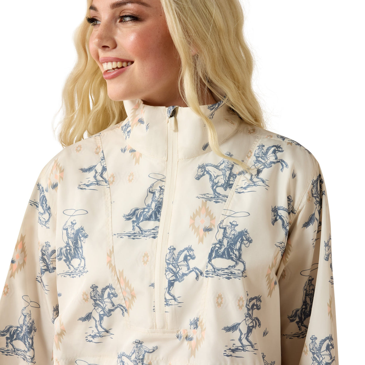 Woman wearing a cream-colored jacket with blue horse and rider pattern on a white background