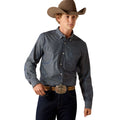 A man wearing a long-sleeve button-down western shirt in a dark blue-gray color, paired with a brown cowboy hat, dark blue jeans, and a brown leather belt with a large silver buckle, photographed against a solid white background.