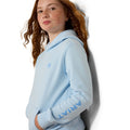 Person wearing a light blue hoodie with 'Ariat' branding on a white background