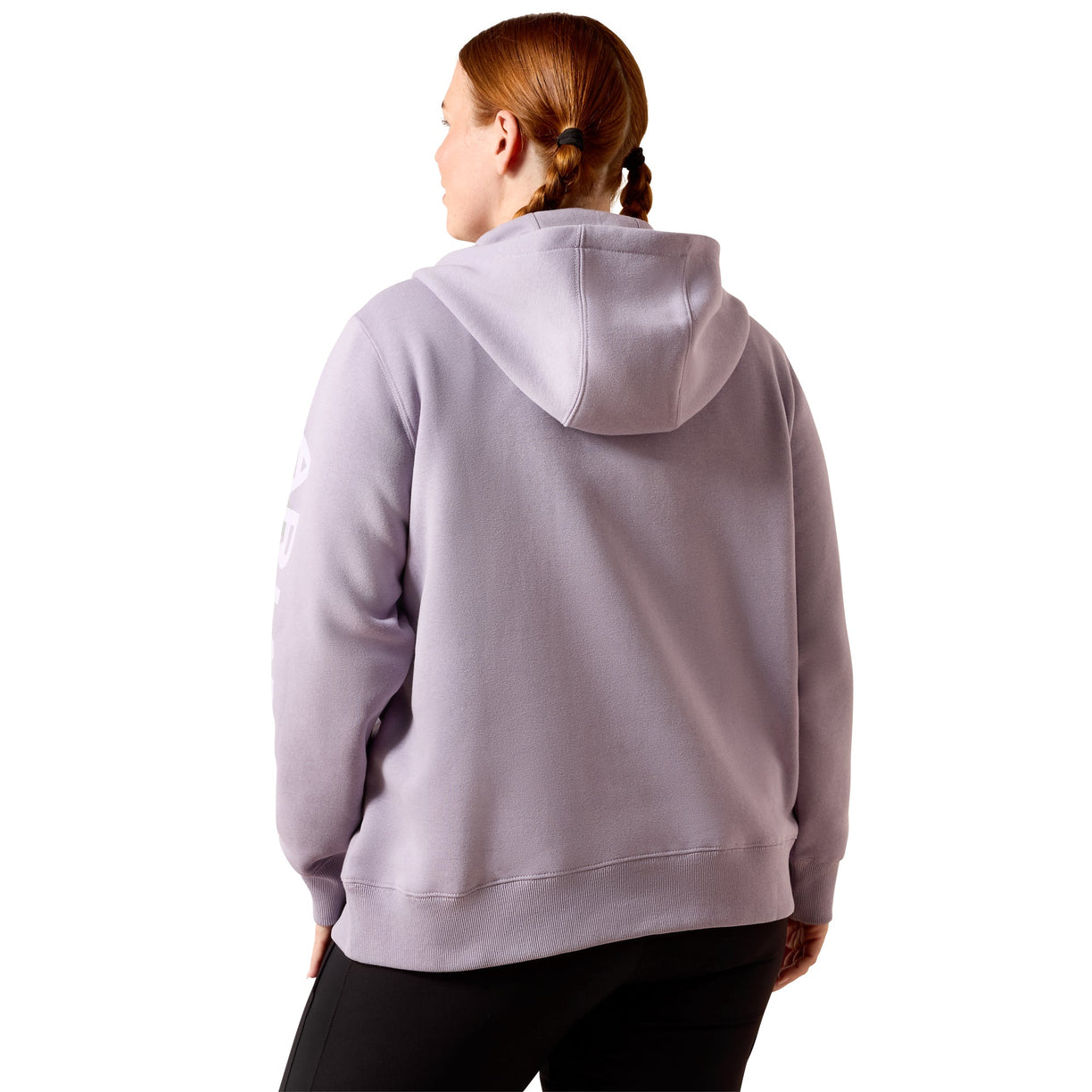 A woman with red hair in a braid is shown from the back wearing a light lavender-purple hoodie and black pants against a solid white background.