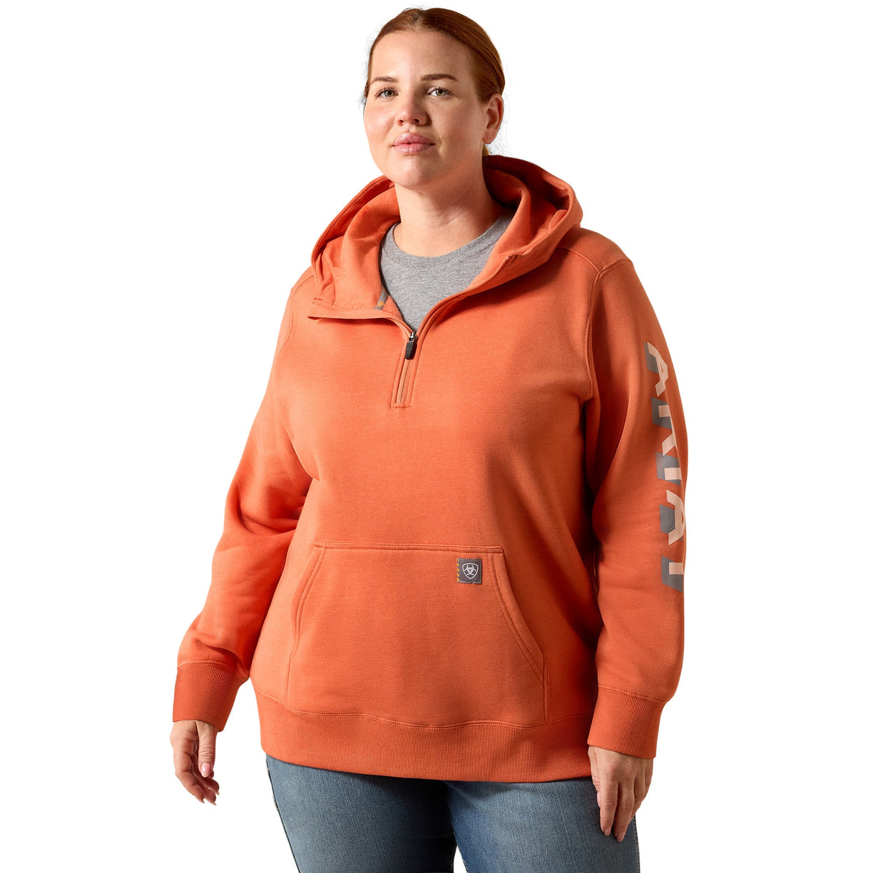 Person wearing an orange hoodie with a brand logo on a white background