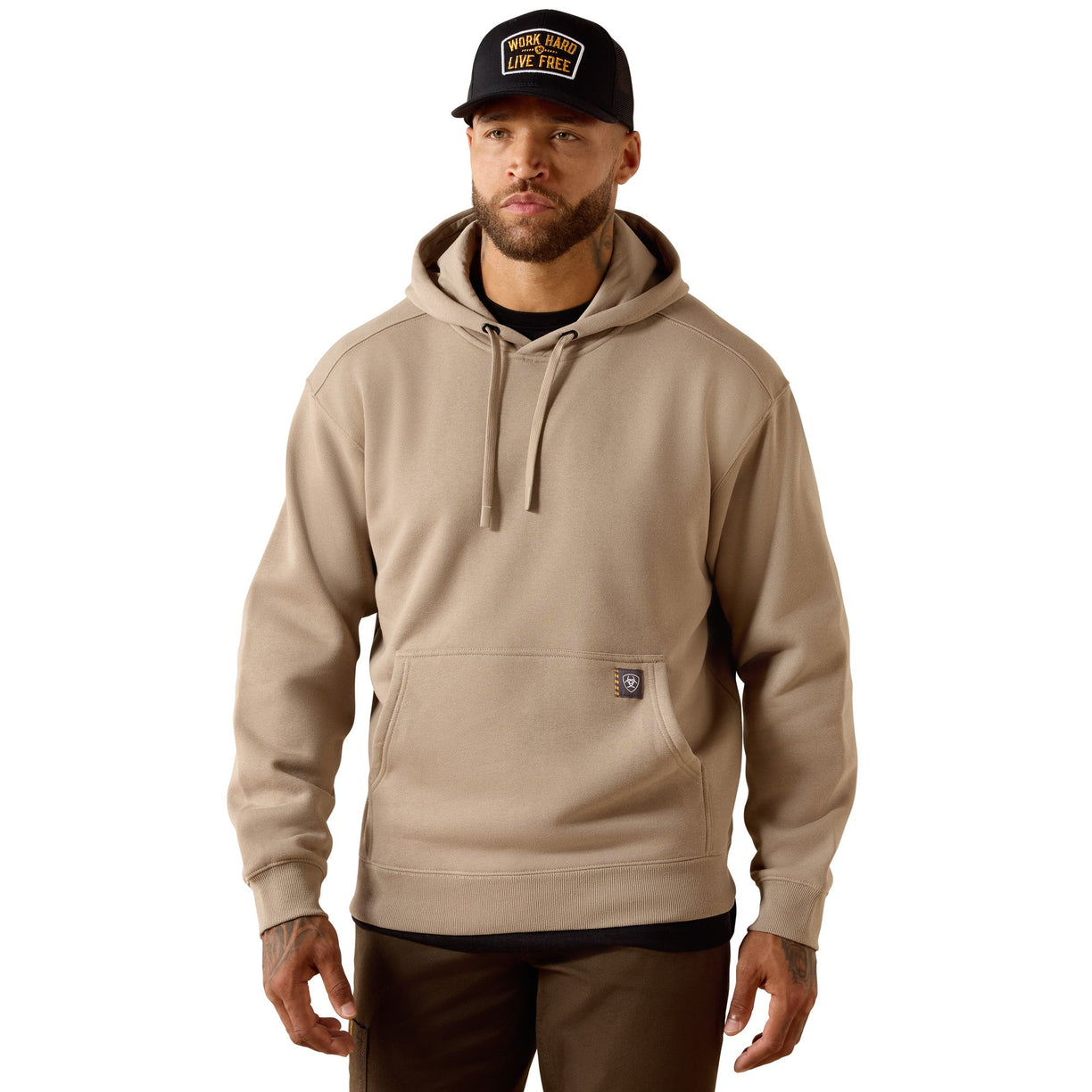Man wearing a beige hoodie and black cap on a white background