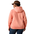 A woman shown from the back wearing a peach-colored pullover hoodie and a brown baseball cap, set against a plain white background.