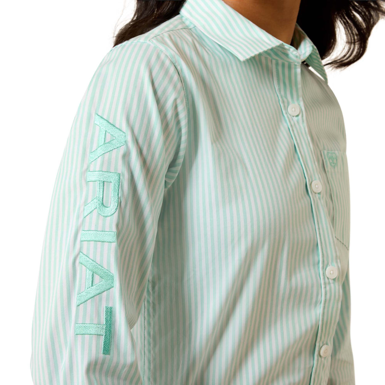 A close-up of a person wearing a mint green and white vertically striped button-up shirt with 'ARIAT' embroidered vertically on the sleeve.