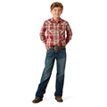 A young boy modeling a red and beige plaid long-sleeve western shirt with blue jeans, brown belt, and brown boots, standing against a solid white background.