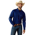 Man wearing a blue shirt with a logo, jeans, and a cowboy hat on a white background