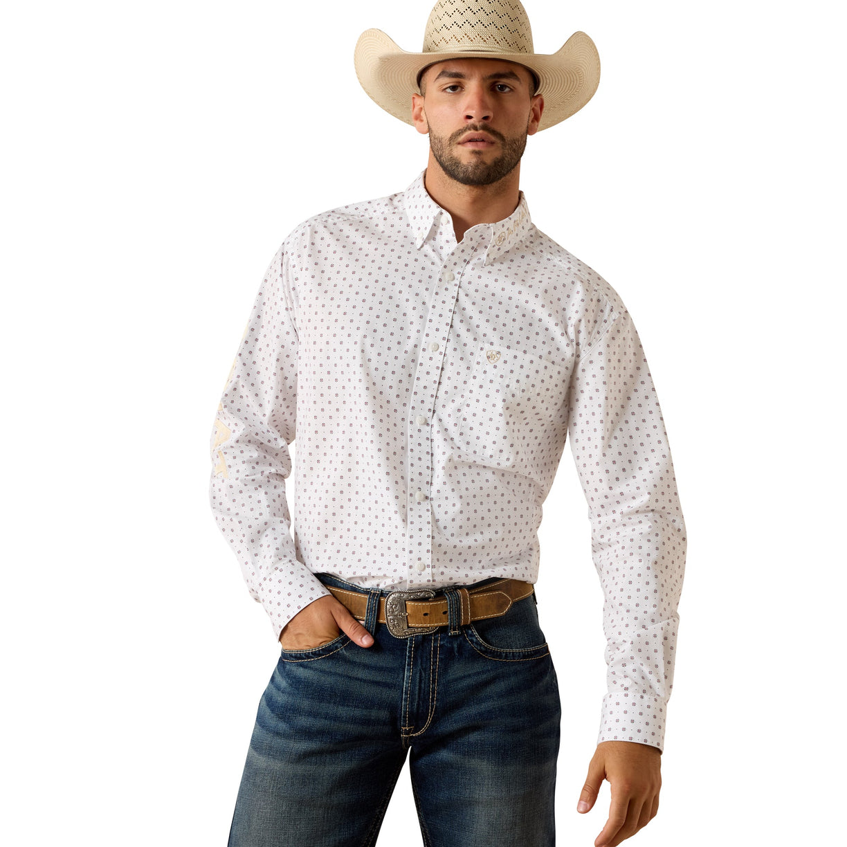 White shirt with a small foulard print, tucked into dark denim with a brown belt.