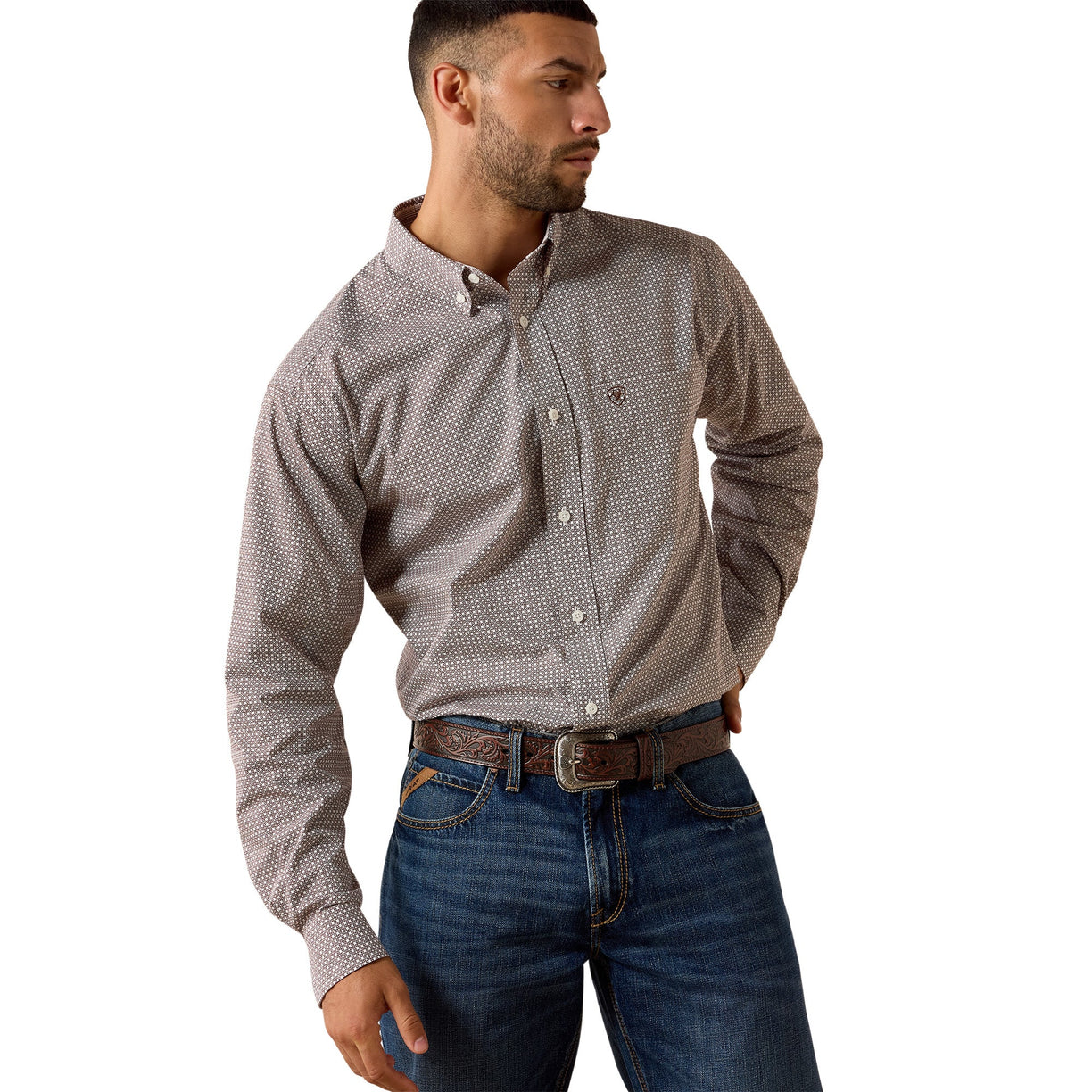 Man wearing a patterned shirt and jeans on a white background