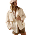 Woman wearing a beige trench coat and beret on a white background